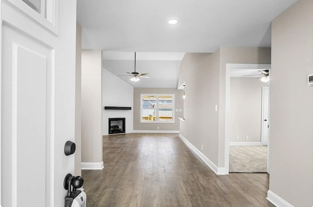 unfurnished living room with ceiling fan, lofted ceiling, a fireplace, and light wood-type flooring