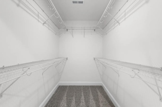 spacious closet featuring dark colored carpet