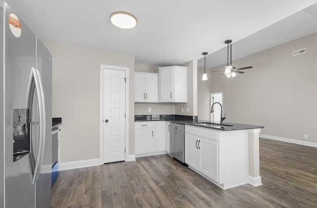 kitchen featuring sink, dark wood-type flooring, stainless steel appliances, white cabinets, and kitchen peninsula