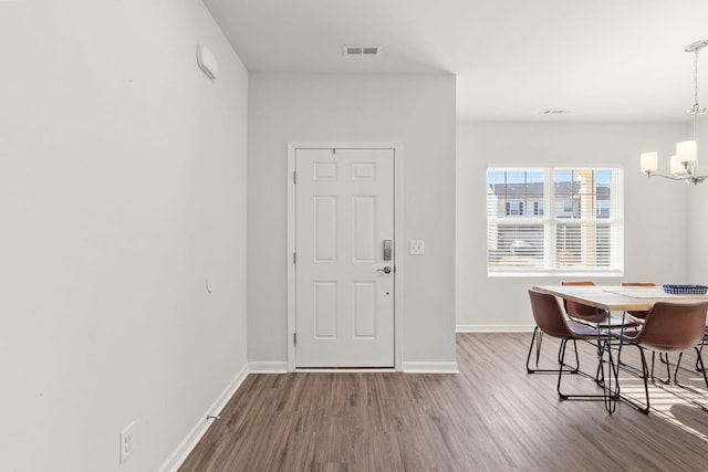 entryway featuring an inviting chandelier and hardwood / wood-style flooring