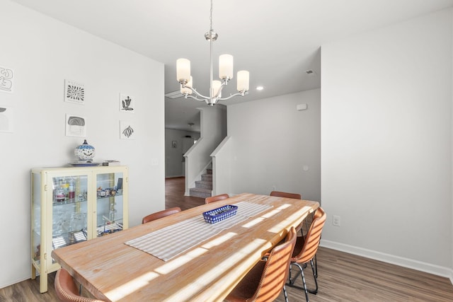 dining space with dark wood-type flooring and a chandelier