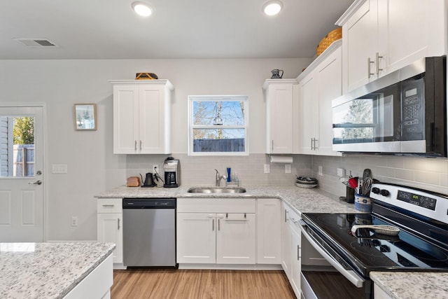 kitchen featuring stainless steel appliances, sink, and white cabinets