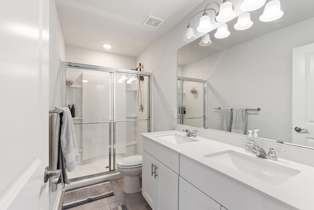 bathroom featuring vanity, toilet, and a shower with shower door