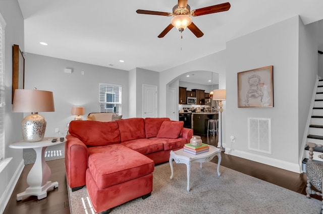 living room with wood-type flooring and ceiling fan