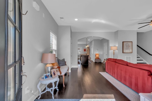 living room with dark wood-type flooring and ceiling fan