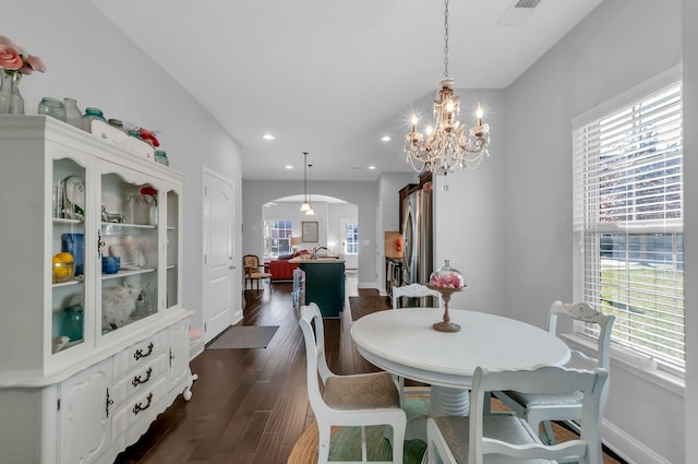 dining room with dark wood-type flooring and a chandelier