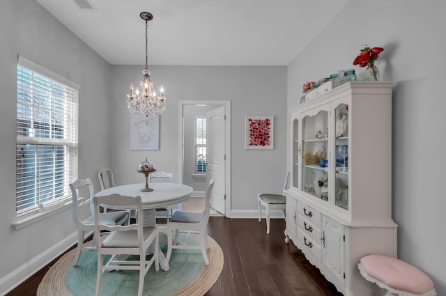 dining area with dark hardwood / wood-style flooring and a chandelier