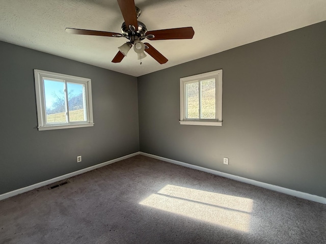 carpeted empty room featuring ceiling fan and a textured ceiling