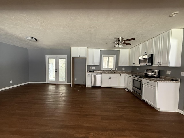 kitchen with dark wood-type flooring, sink, white cabinetry, a textured ceiling, and stainless steel appliances