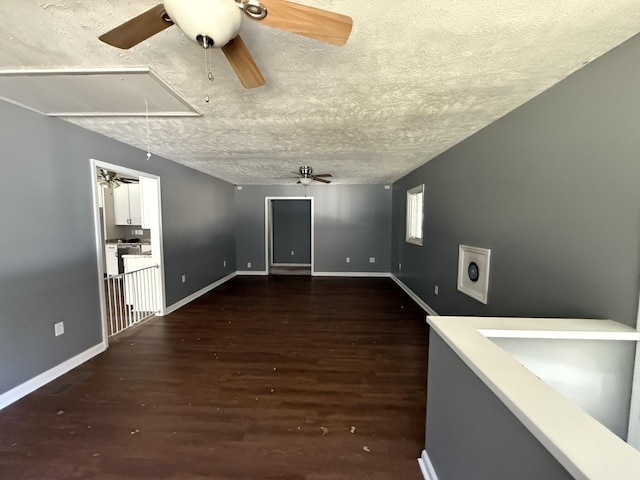 unfurnished room featuring dark wood-type flooring, ceiling fan, and a textured ceiling