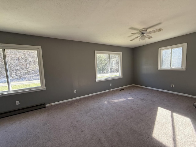 carpeted spare room featuring ceiling fan, a baseboard radiator, and a textured ceiling