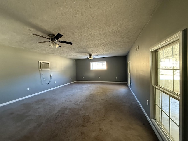 spare room with ceiling fan, dark carpet, a textured ceiling, and a wall unit AC