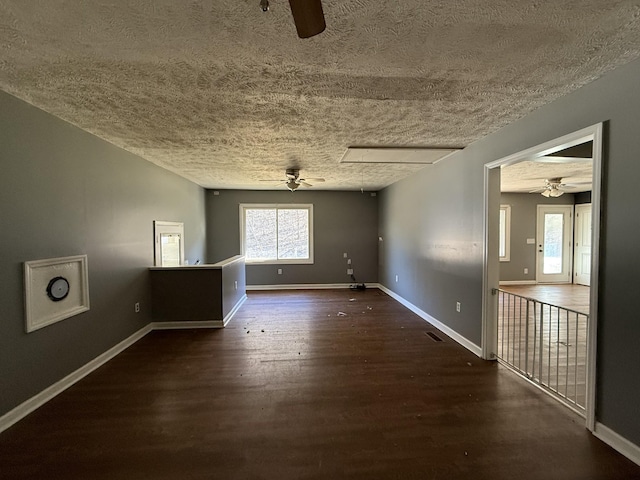 empty room featuring ceiling fan, a textured ceiling, and dark hardwood / wood-style flooring