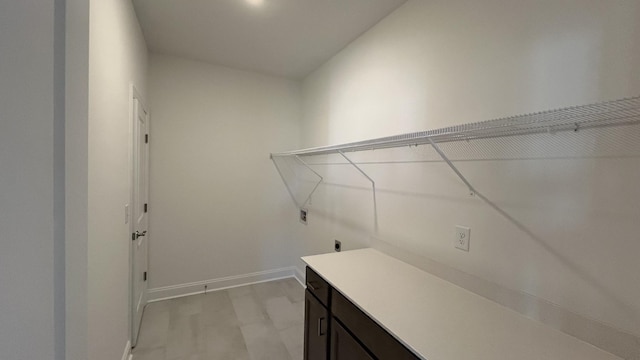 clothes washing area featuring cabinets and hookup for an electric dryer