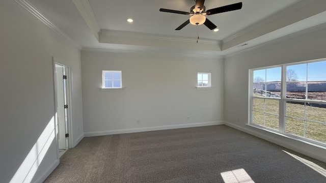 carpeted empty room with ceiling fan, ornamental molding, and a raised ceiling