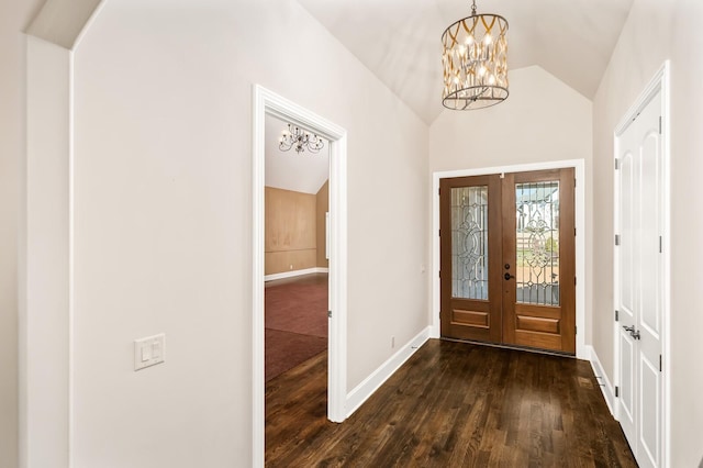 foyer entrance with lofted ceiling, a notable chandelier, dark hardwood / wood-style floors, and french doors