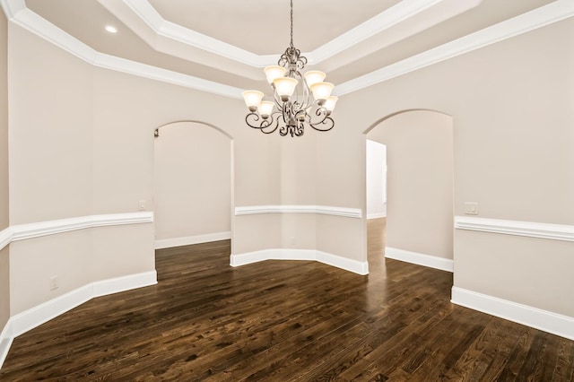 unfurnished room featuring crown molding, dark hardwood / wood-style floors, a raised ceiling, and a chandelier