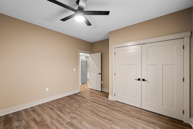 unfurnished bedroom featuring ceiling fan, light wood-type flooring, and a closet