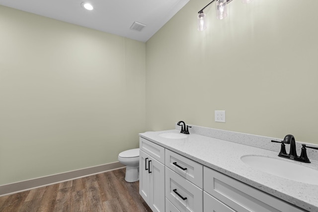 bathroom featuring hardwood / wood-style flooring, vanity, and toilet