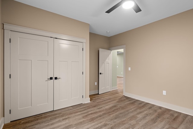 unfurnished bedroom with ceiling fan, light hardwood / wood-style floors, and a closet