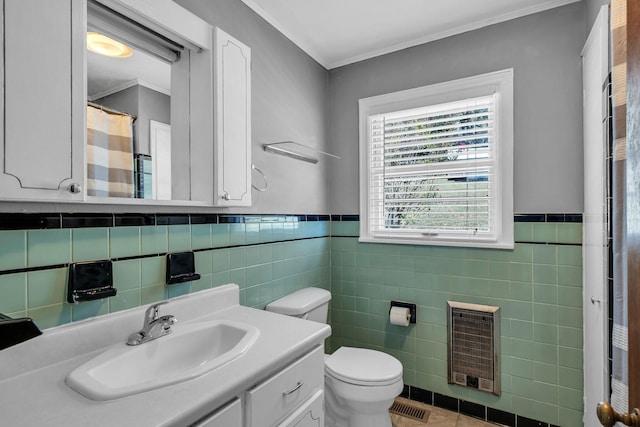 bathroom with ornamental molding, vanity, toilet, and heating unit