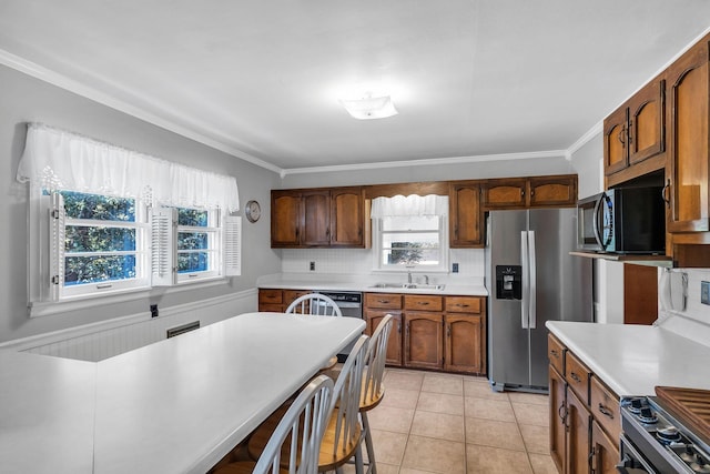 kitchen with crown molding, sink, light tile patterned floors, and appliances with stainless steel finishes