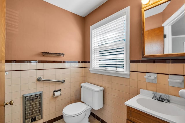 bathroom with vanity, toilet, and heating unit