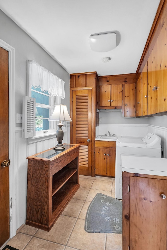 kitchen featuring light tile patterned flooring, sink, and independent washer and dryer