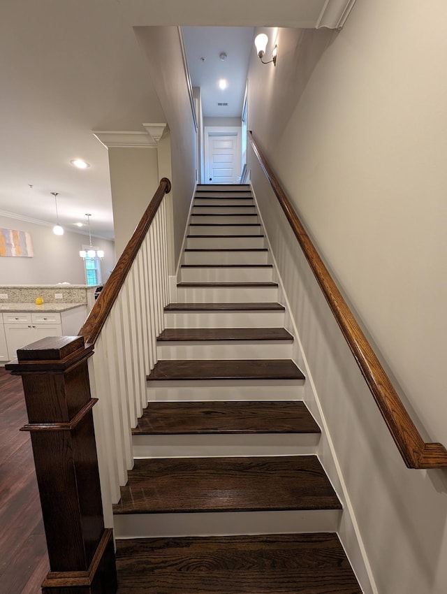 stairs with wood-type flooring and ornamental molding