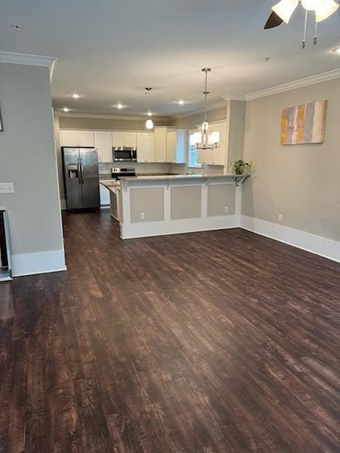 kitchen with white cabinetry, decorative light fixtures, ornamental molding, kitchen peninsula, and stainless steel appliances