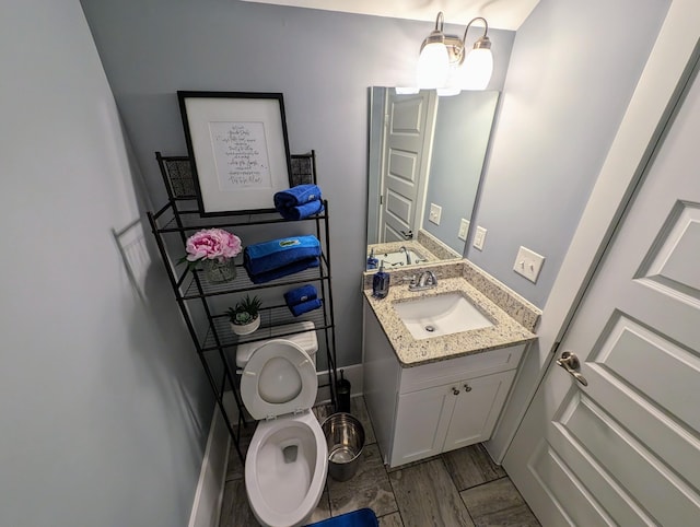 bathroom with vanity, hardwood / wood-style flooring, and toilet