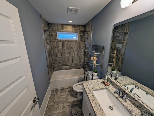 full bathroom featuring tiled shower / bath, vanity, and toilet