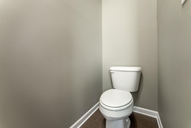 bathroom featuring toilet, baseboards, and wood finished floors