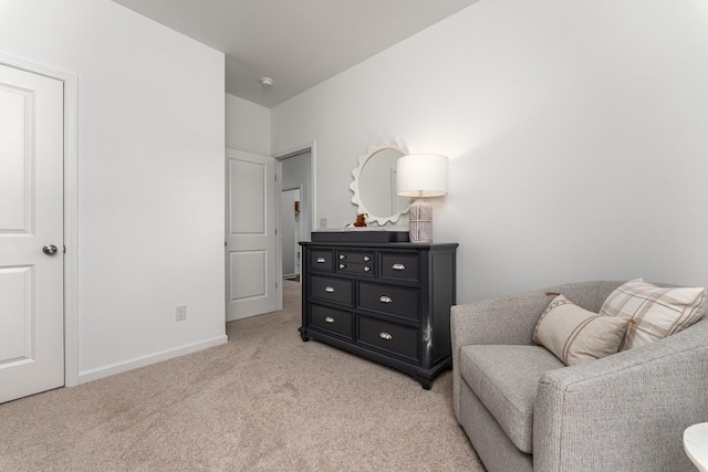 sitting room featuring light carpet and baseboards