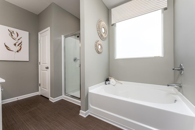 bathroom featuring baseboards, a garden tub, vanity, and a shower stall