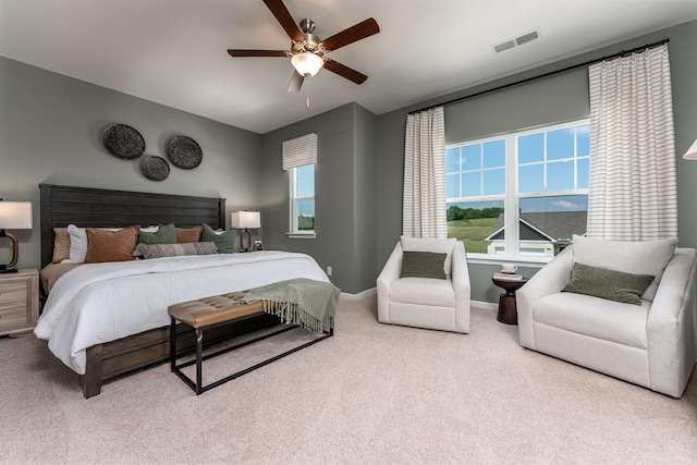 carpeted bedroom featuring a ceiling fan, visible vents, baseboards, and multiple windows