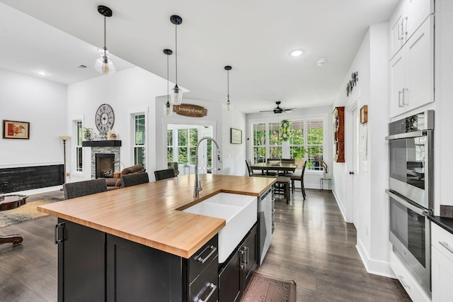 kitchen featuring hanging light fixtures, white cabinetry, a center island, and stainless steel appliances