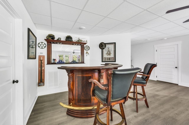 bar featuring a drop ceiling and dark hardwood / wood-style floors