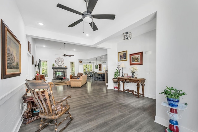 living room with hardwood / wood-style flooring, ceiling fan, and a fireplace