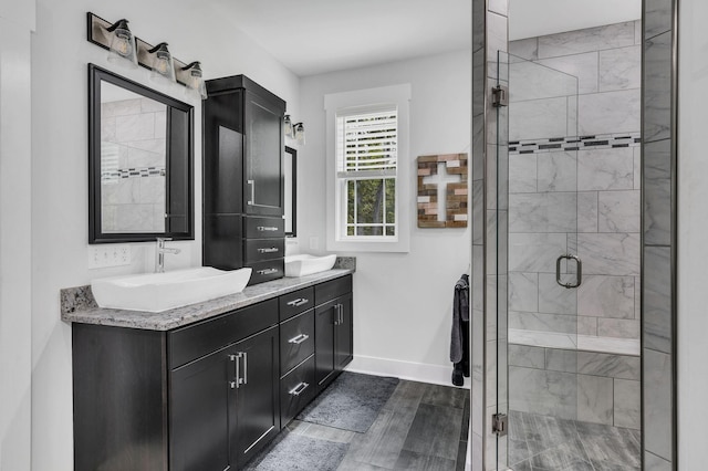 bathroom with walk in shower, vanity, and hardwood / wood-style floors