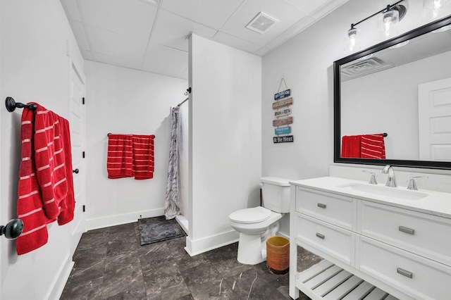 bathroom featuring a paneled ceiling, vanity, toilet, and curtained shower