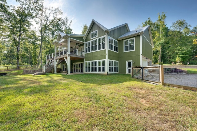 rear view of house with a garage, a deck, and a lawn