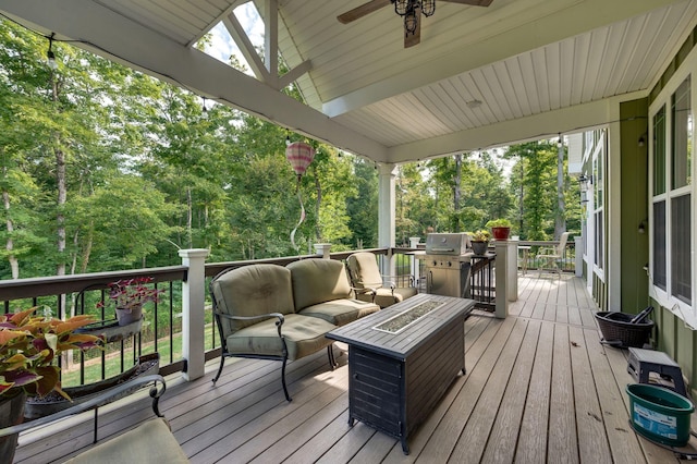 deck with an outdoor living space with a fire pit and ceiling fan