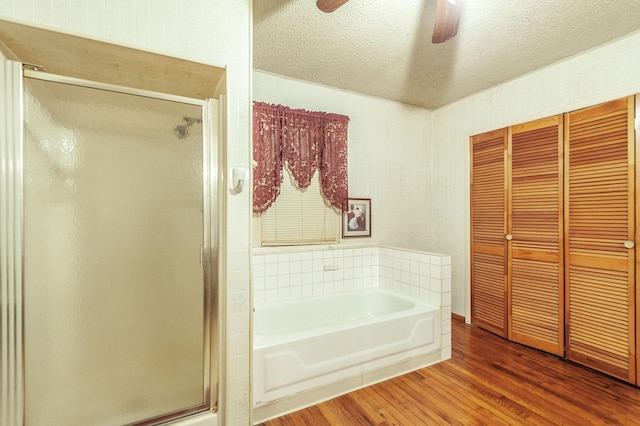 bathroom featuring hardwood / wood-style floors, independent shower and bath, and a textured ceiling