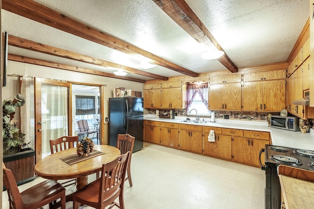 kitchen with beamed ceiling, sink, a textured ceiling, and black appliances