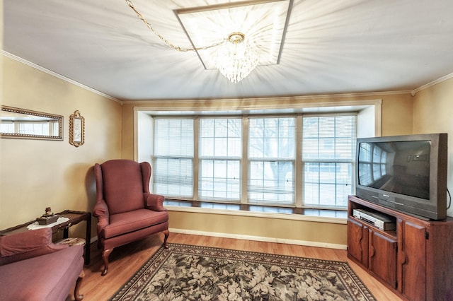 sitting room featuring a notable chandelier, ornamental molding, light hardwood / wood-style floors, and plenty of natural light