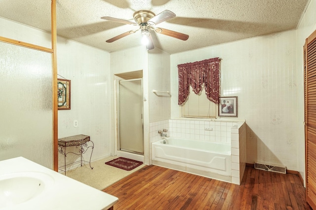 bathroom featuring sink, hardwood / wood-style flooring, ceiling fan, a textured ceiling, and independent shower and bath