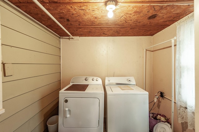 clothes washing area with wood ceiling and washer and clothes dryer