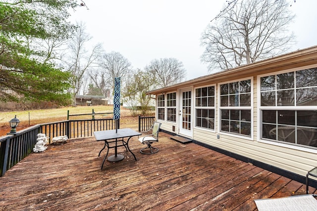 wooden deck featuring a lawn and a sunroom