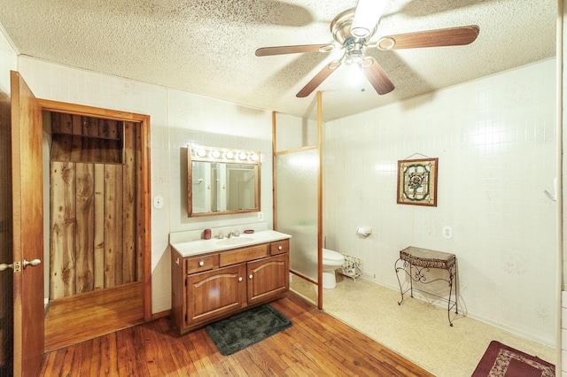 bathroom with wood-type flooring, vanity, and a textured ceiling